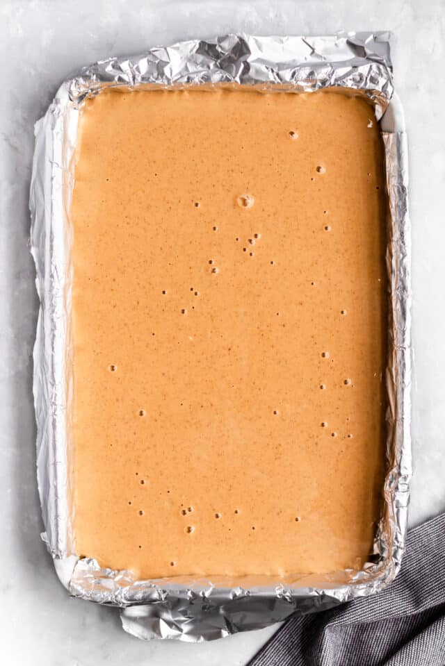 pour filling of pumpkin cheesecake bars over graham cracker crust 