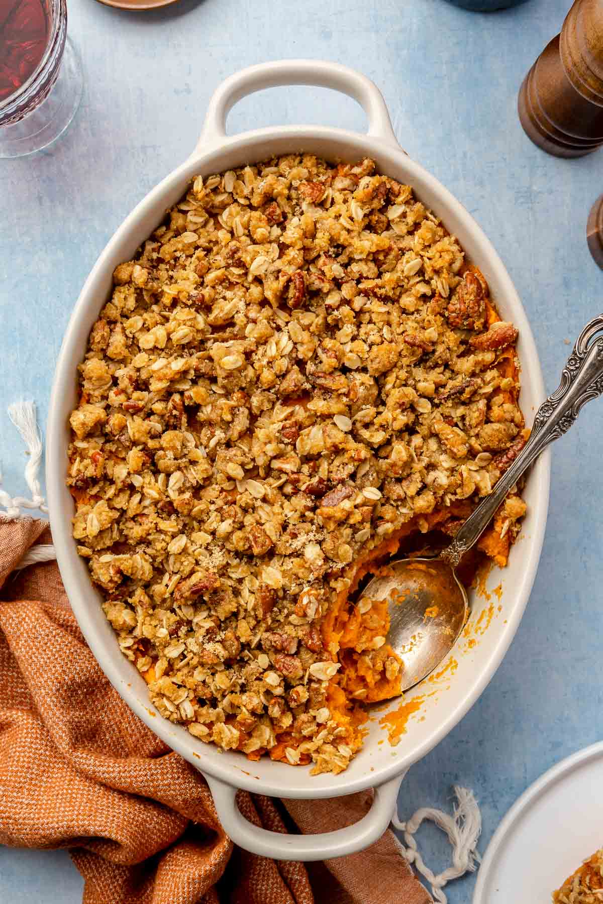 Sweet potato casserole in a white dish with a serving spoon.