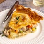 Serving of turkey pot pie on a white plate with a fork.