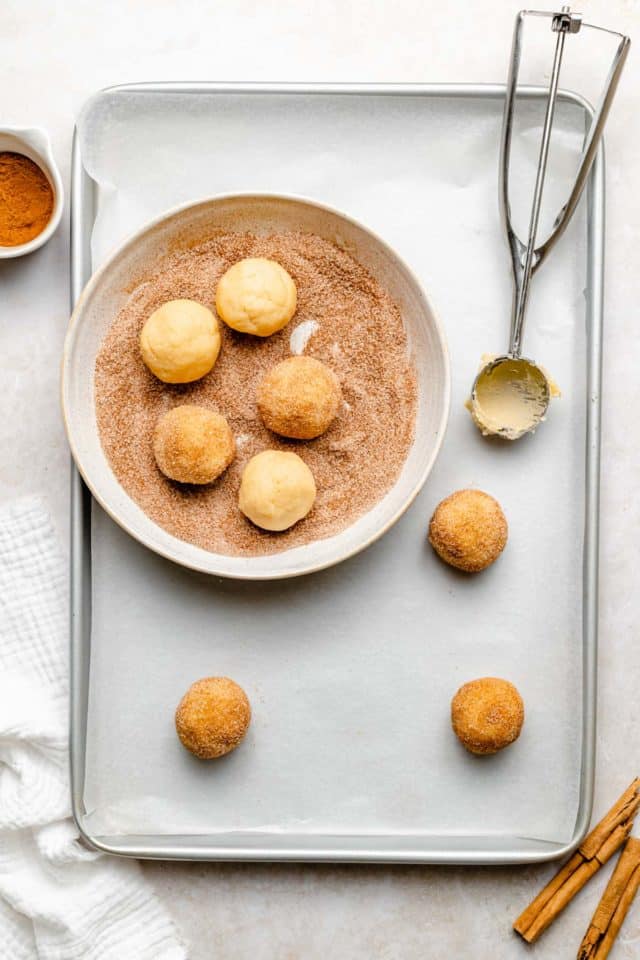 scooping dough balls to roll in cinnamon sugar mixture