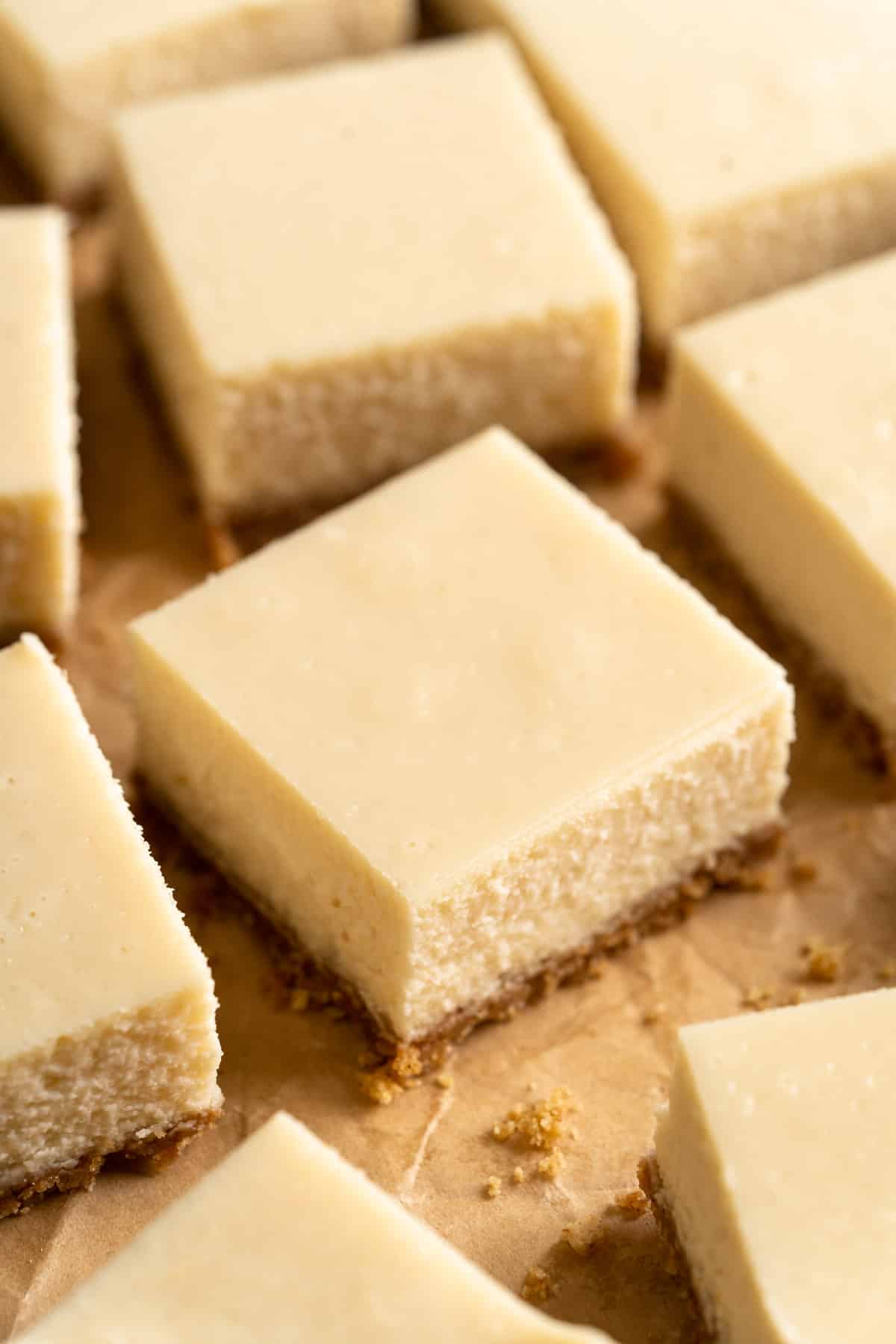 Cheesecake bars on parchment paper.