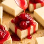 Drizzling cherry pie filling over cheesecake bar.