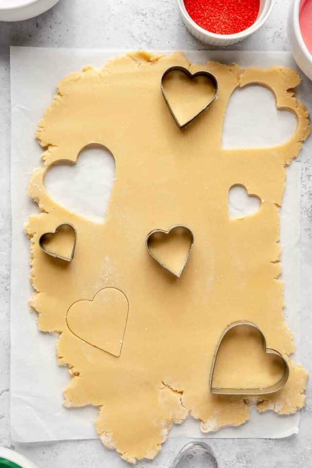 Using heart cookie cutters to cut out sugar cookies.