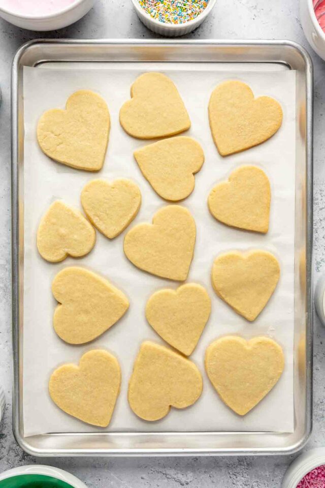 Baked heart-shaped sugar cookies on a pan.