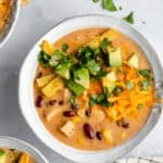creamy chicken tortilla soup topped with cheese, avocado and fresh cilantro