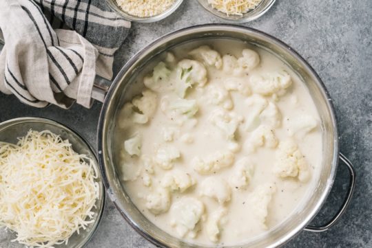 cooking cauliflower with milk, cheese and flour in a large saucepan