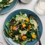 salad with butternut squash and sliced pear served on a blue plate with a fork
