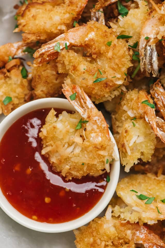 coconut shrimp dipped in cocktail sauce