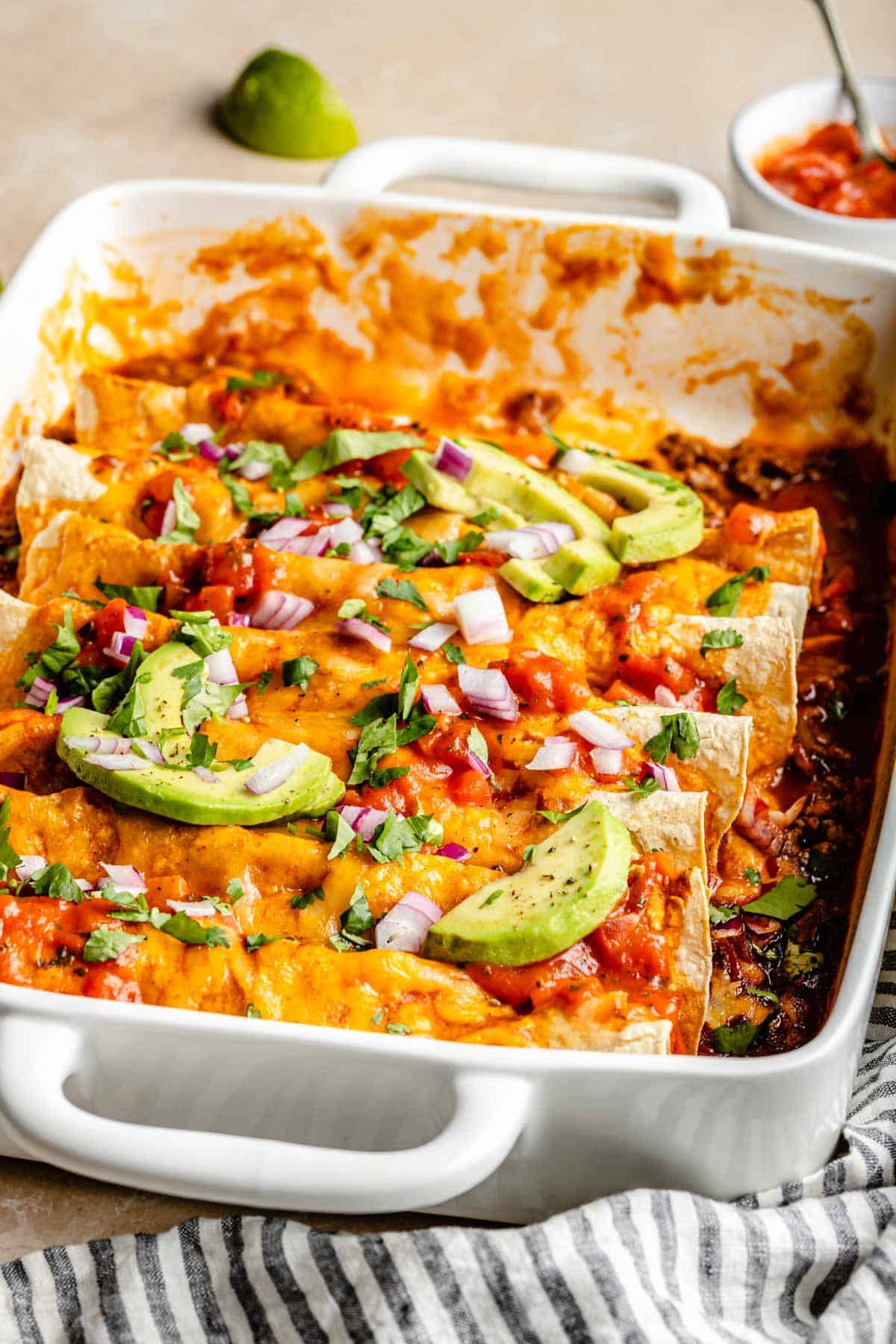 Dish filled with cheesy enchiladas.