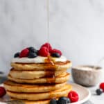 stack of yogurt pancakes with maple syrup dripping down the side