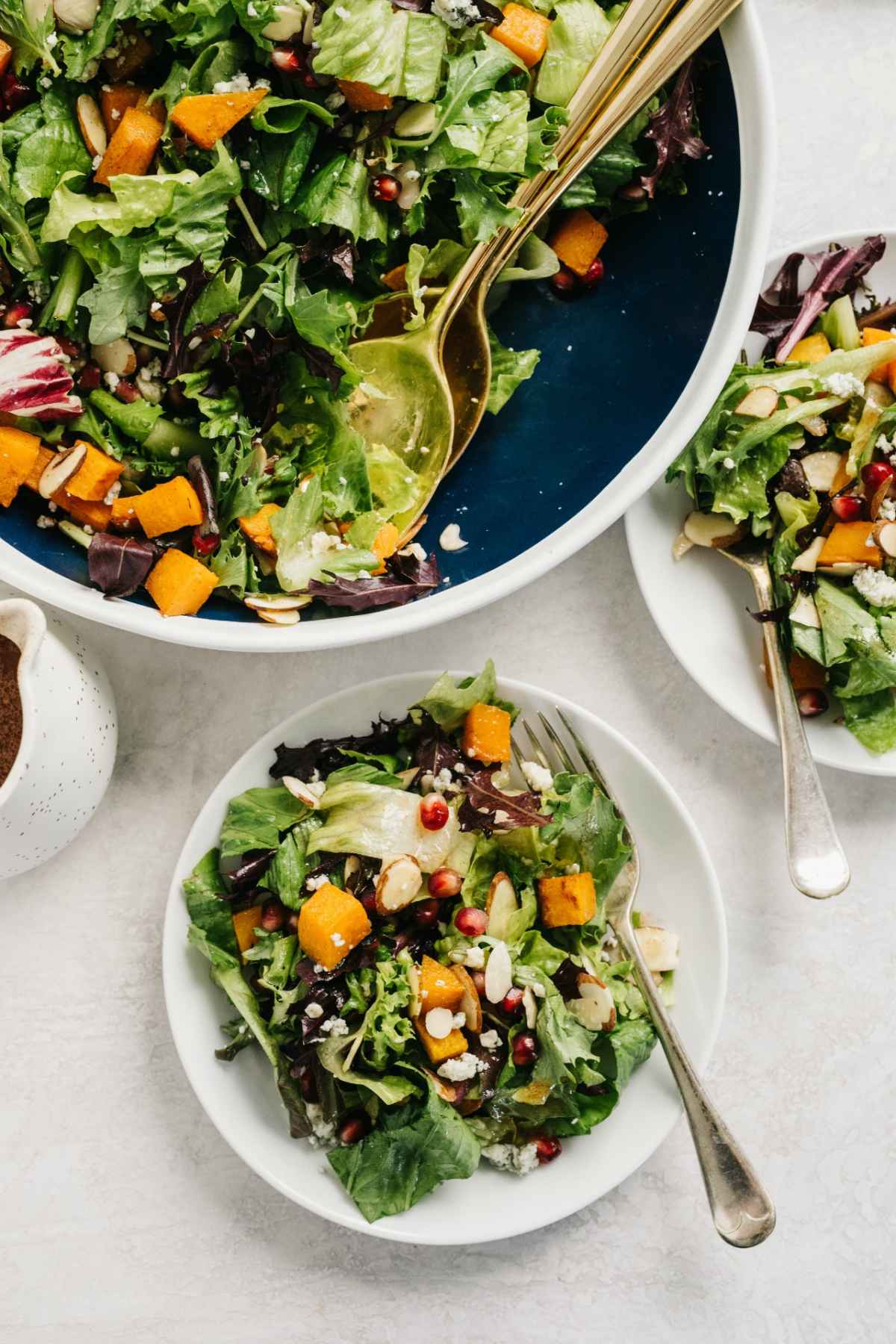Salad topped with butternut squash, cheese and almonds.