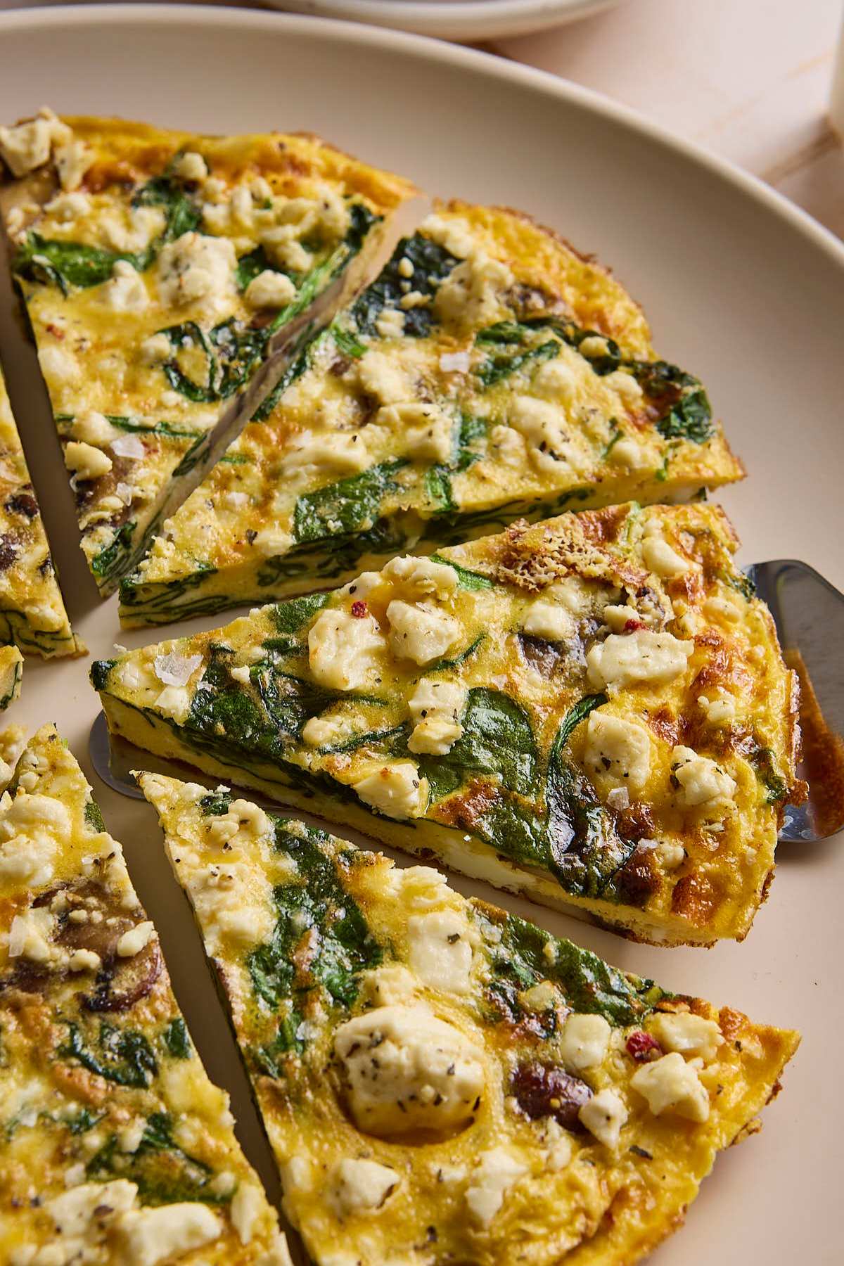 Veggie frittata sliced into servings on a plate.