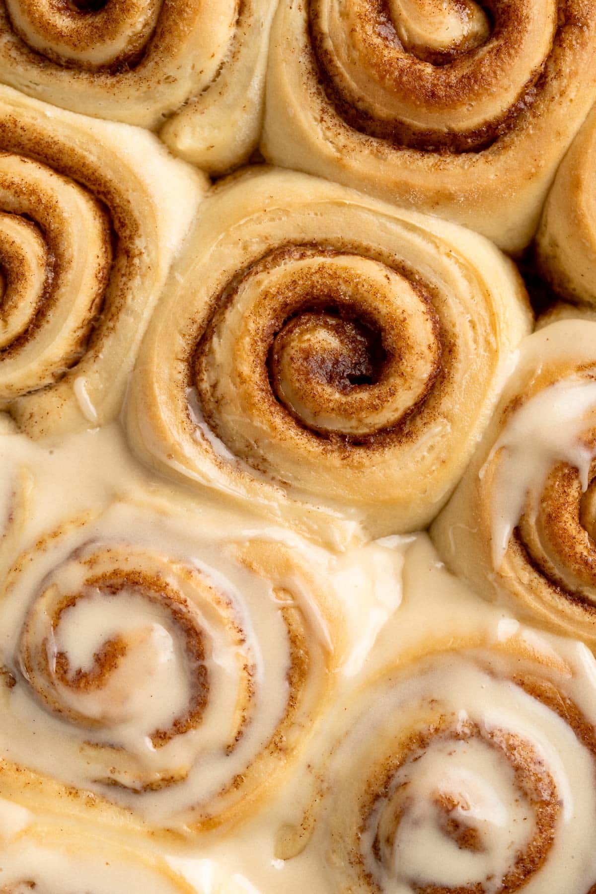 Close up view of cinnamon rolls some with icing and some without.