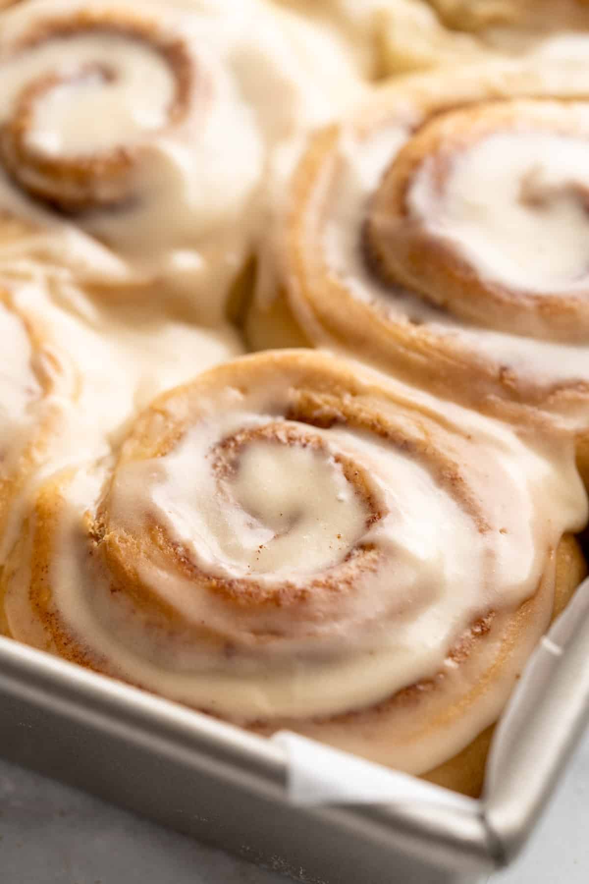 Closeup view of cinnamon roll with icing.