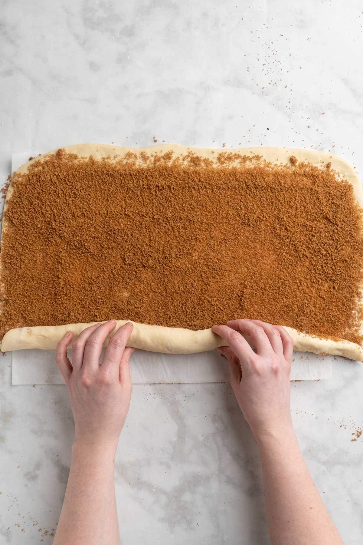 Rolling dough into a long log shape.