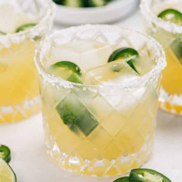 A jalapeño margarita in a glass with a salted rim.