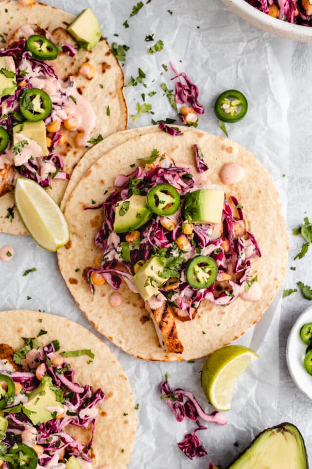 chicken tacos topped with slaw, jalapeño and avocado
