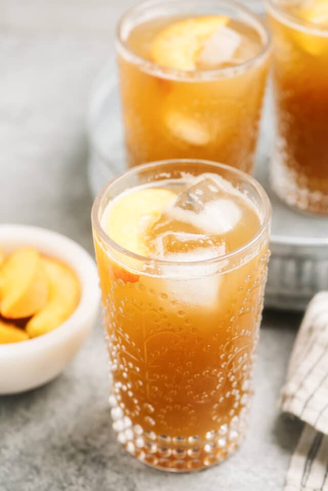 sweet tea peach cocktail served with fresh peaches