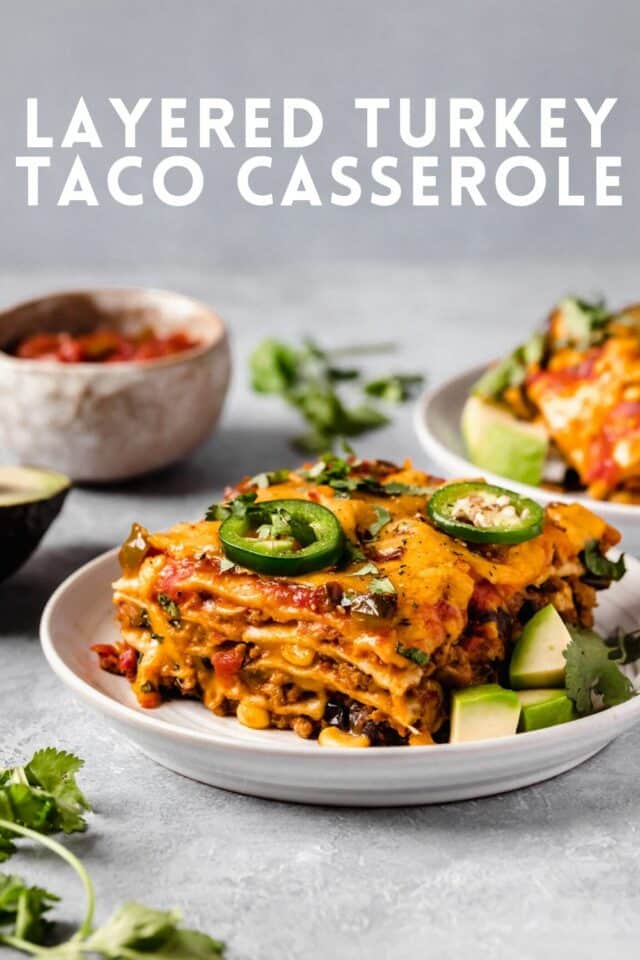 Layered Taco Casserole served with salsa and sliced avocado