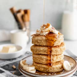 stack of whole wheat pancakes with maple syrup drizzling down the side