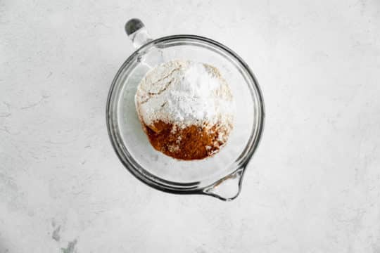 mixing flour with cinnamon and baking powder in a large measuring glass