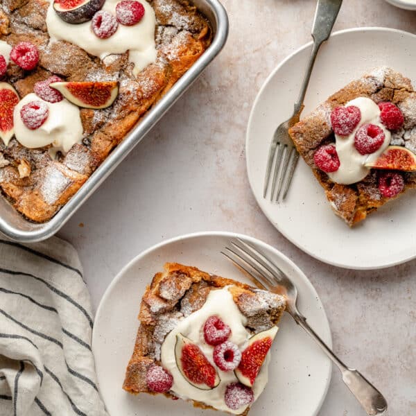 French toast casserole served on small white plates and topped with fresh figs and raspberries