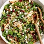 Farro salad in a large serving bowl with 2 wooden serving spoons.