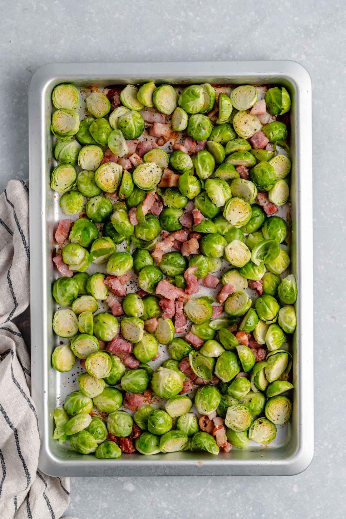 Brussel sprouts and bacon on a large sheet pan.