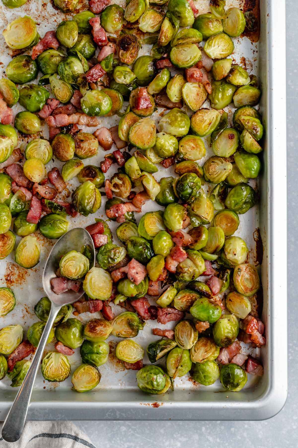 Roasted brussel sprouts with bacon on a cookie sheet.