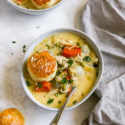 chicken pot pie soup served with a biscuit on top