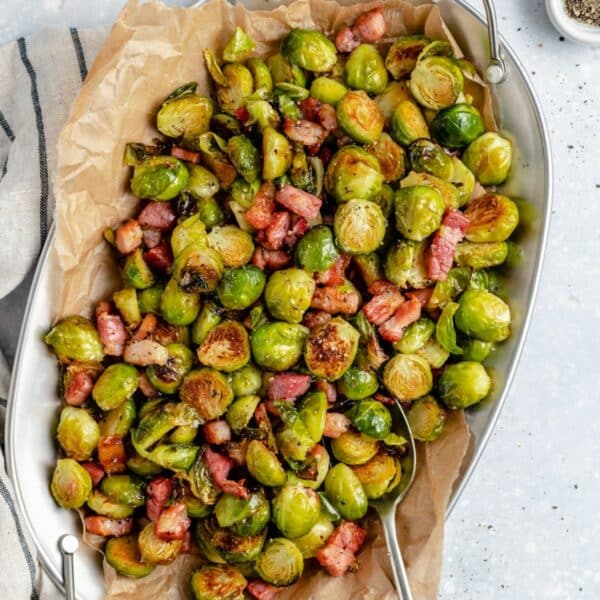Serving bowl filled with bacon roasted Brussels sprouts.