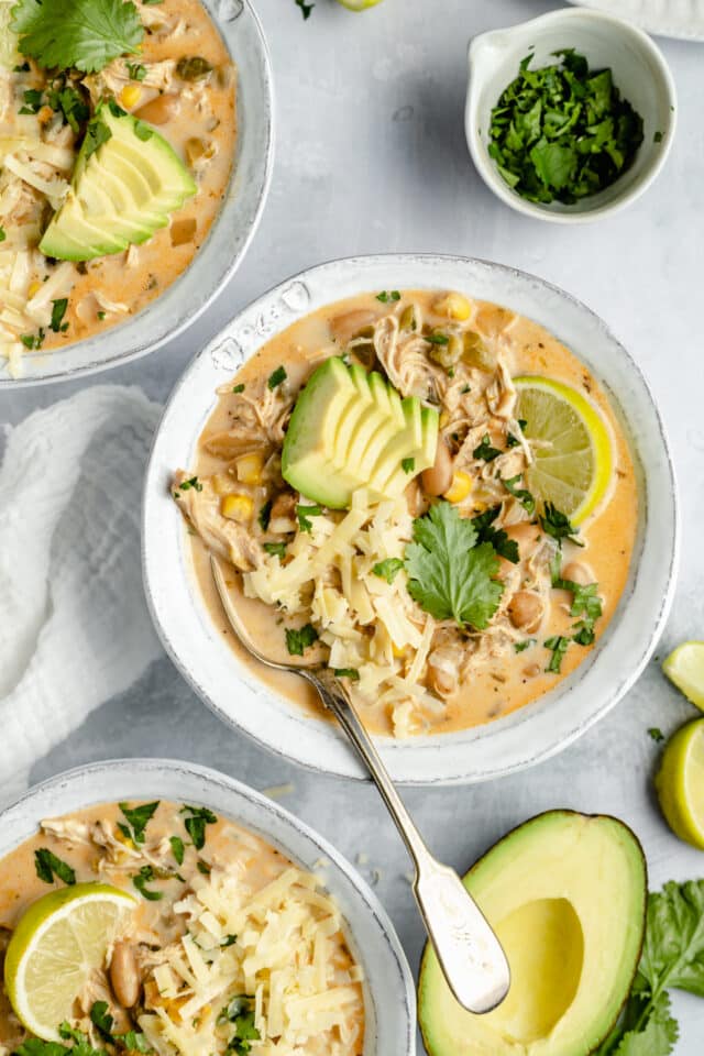 bowl filled with creamy chicken chili and garnished with a slice of lime 