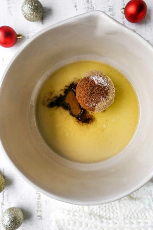 Mixing brown sugar and spices with melted butter in a large bowl.