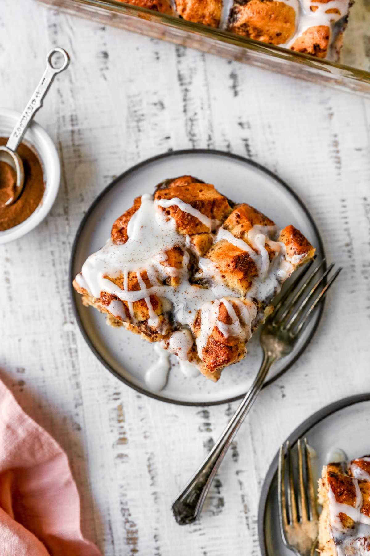 Sweet piece of breakfast bake drizzled with icing served on a plate.