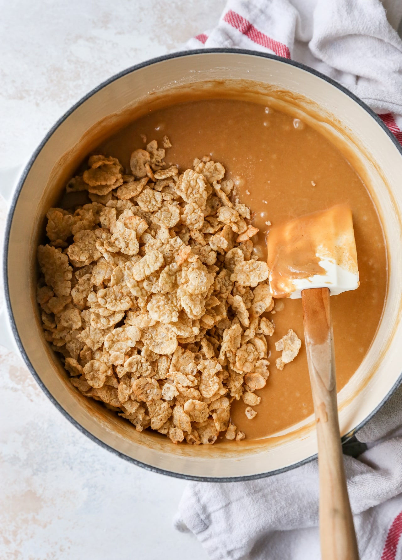 Stirring peanut butter mixture with Special K cereal in a pot.