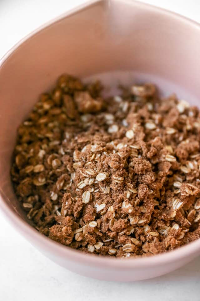 mixing brown sugar, oats, flour and cinnamon in a bowl for streusel muffin topping