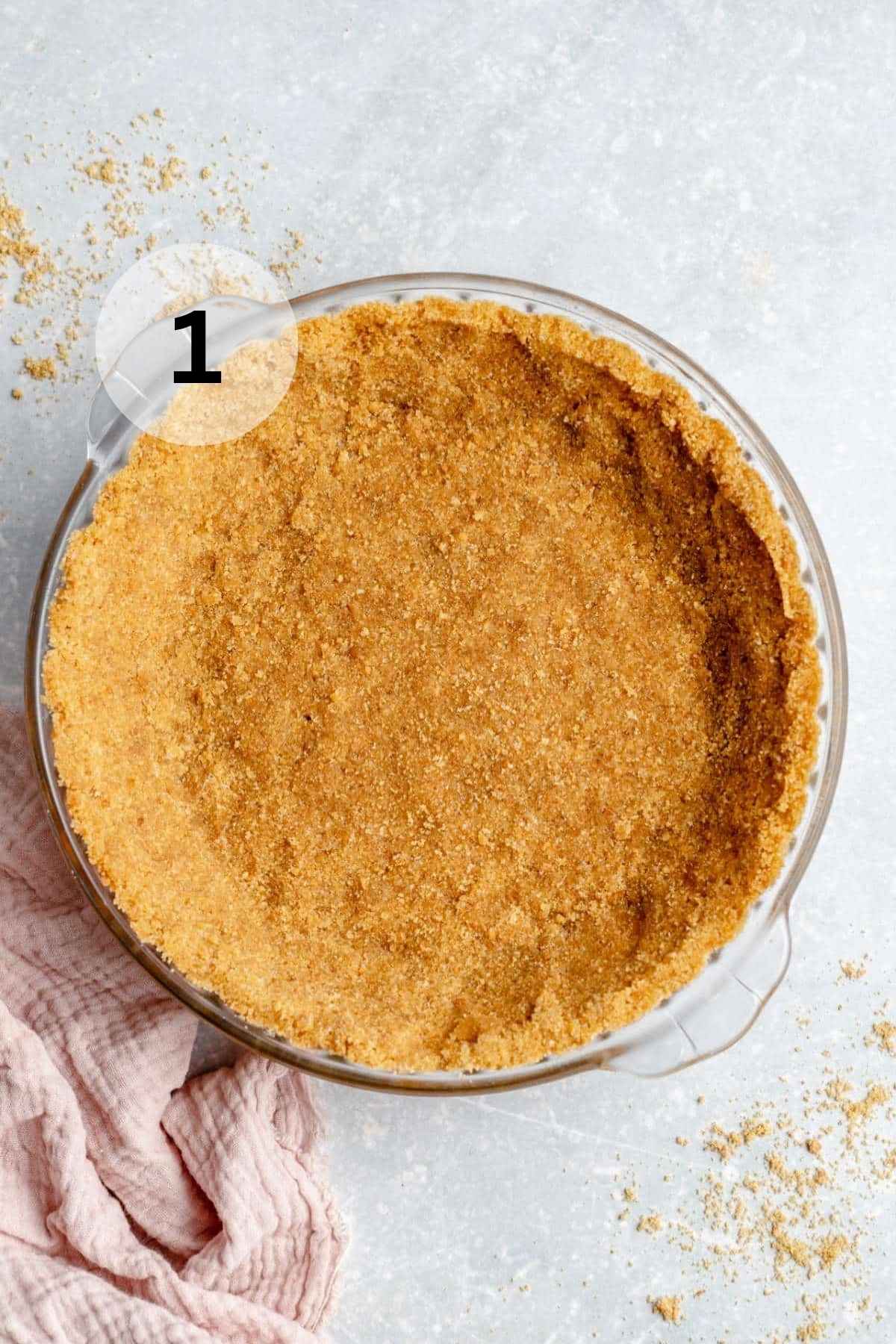 Graham cracker crust in a pie plate.