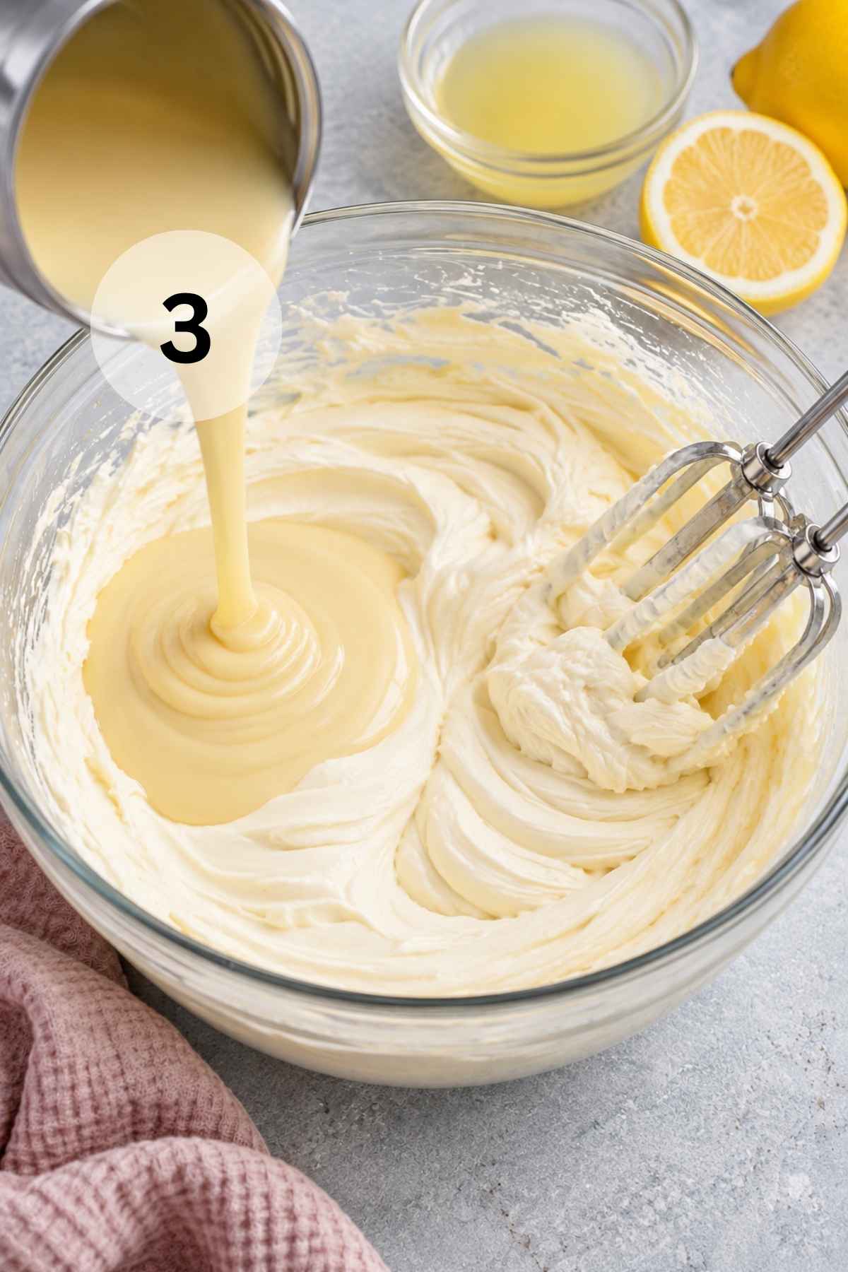 Pouring sweetened condensed milk into a bowl with beaten cream cheese.
