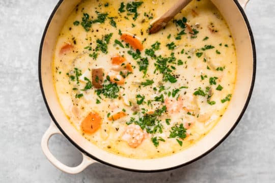 Seafood chowder simmering in a large pot.