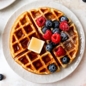 buttermilk waffles served with butter, maple syrup and berries