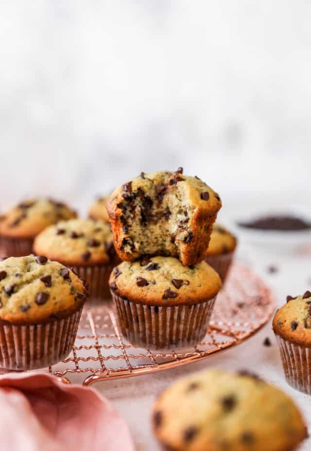 one chocolate chip muffin with a bite taken out stacked on another muffin