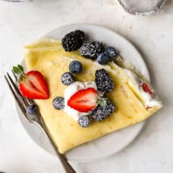 folded crepe filled with whipped cream and fresh berries