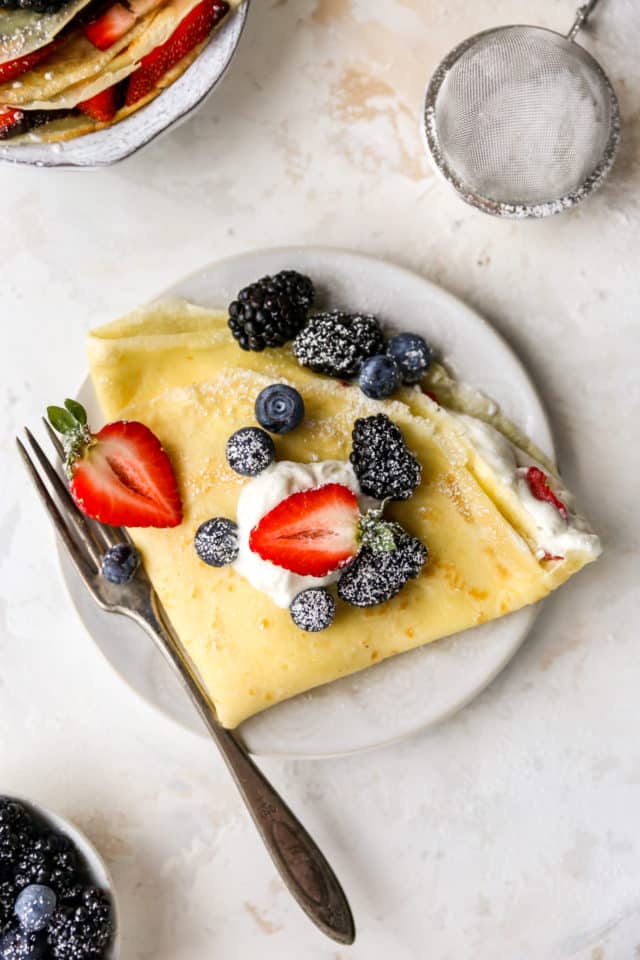 folded crepe filled with whipped cream and fresh berries