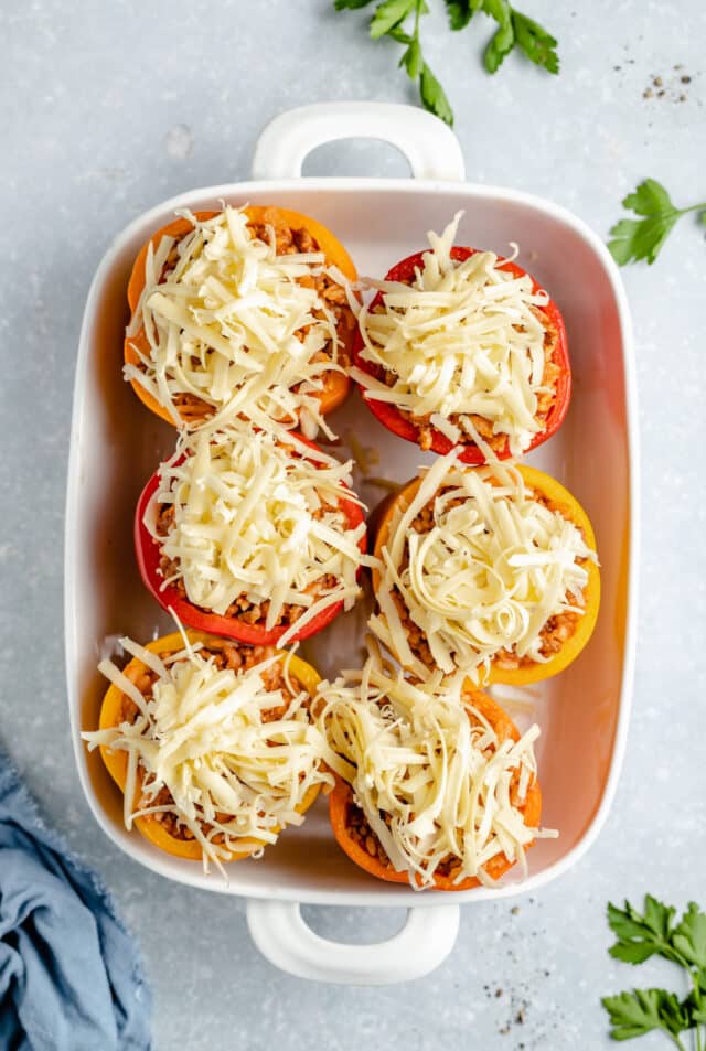 stuffed bell peppers topped with shredded cheese before baking