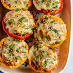 Stuffed peppers topped with melty cheese and parsley.