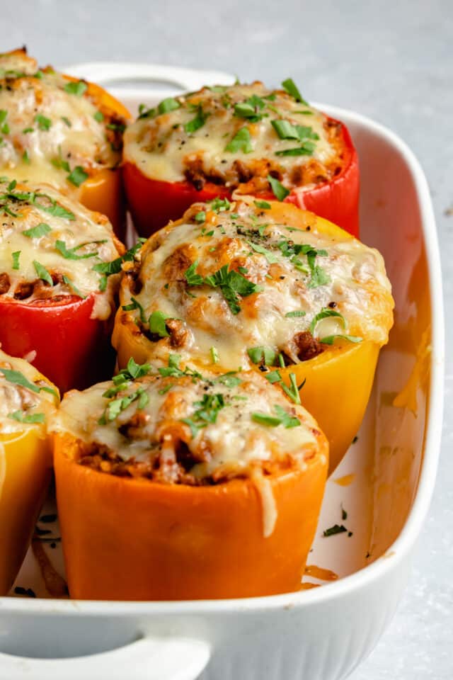 cooked bell peppers stuffed with ground beef, rice and topped with melted cheese