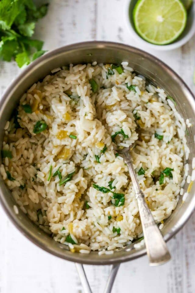 Fluffing cilantro lime rice with a fork.