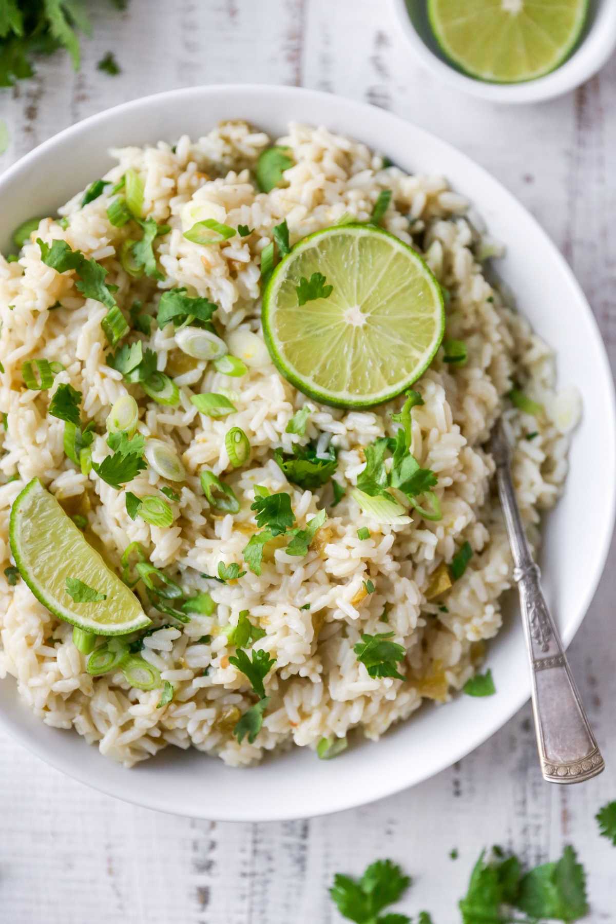 Cilantro lime rice topped with cilantro and lime wedges.