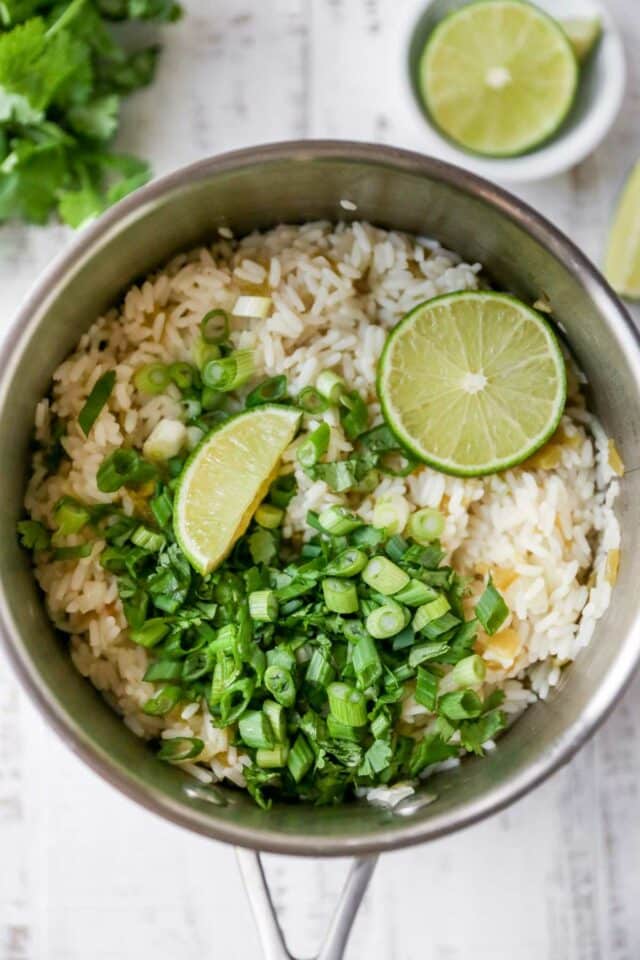 Limes, green onions and cilantro added to white rice.