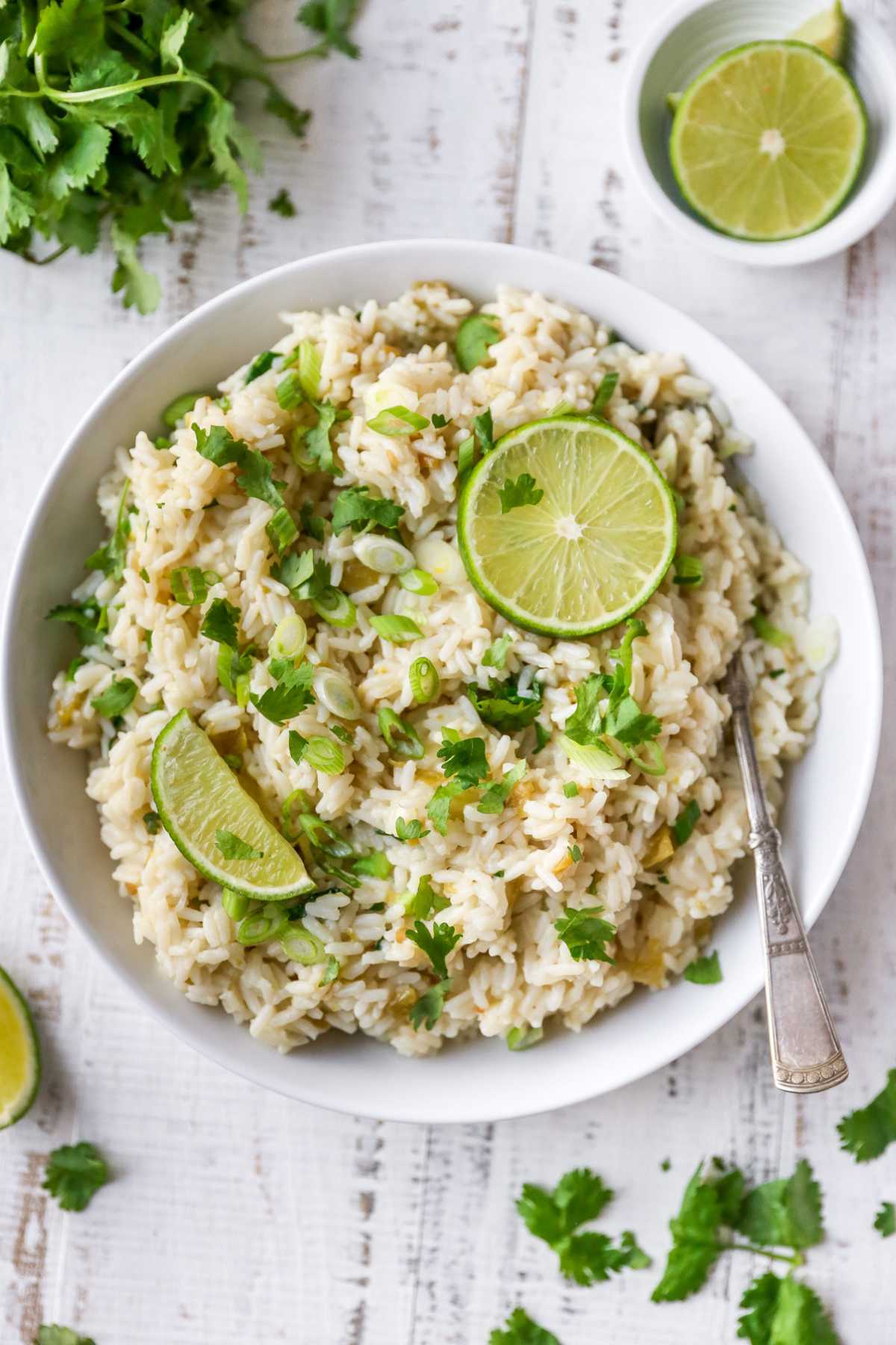 Cilantro lime rice served in a white bowl with limes.